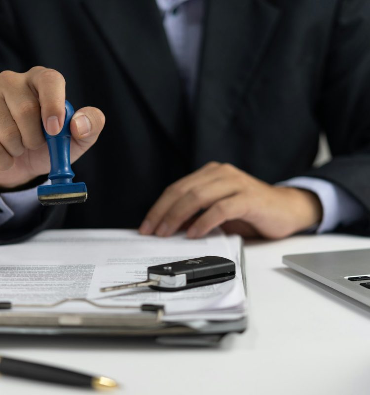 Businessman signing a contract for buying of selling a car.Car rental service.